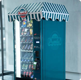 Máquina de venda automática de snacks e bebidas ao lado de um equipamento azul, ideal para conveniência em locais públicos, promovendo vendas rápidas e seguras.