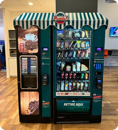 Máquina de venda automática de café e produtos diversos, instalada em ambiente interno com painel de pagamento digital ao lado.